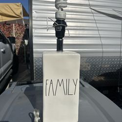 Rae Dunn "FAMILY" ceramic table lamp, typically featuring a white rectangular base with stylized black lettering in the artist's signature font.