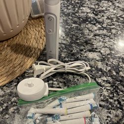 Oral-B Electric toothbrush with several new replacement brush heads and charger. See pictures