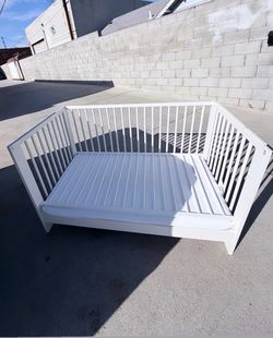 White wooden slatted crib and toddler bed