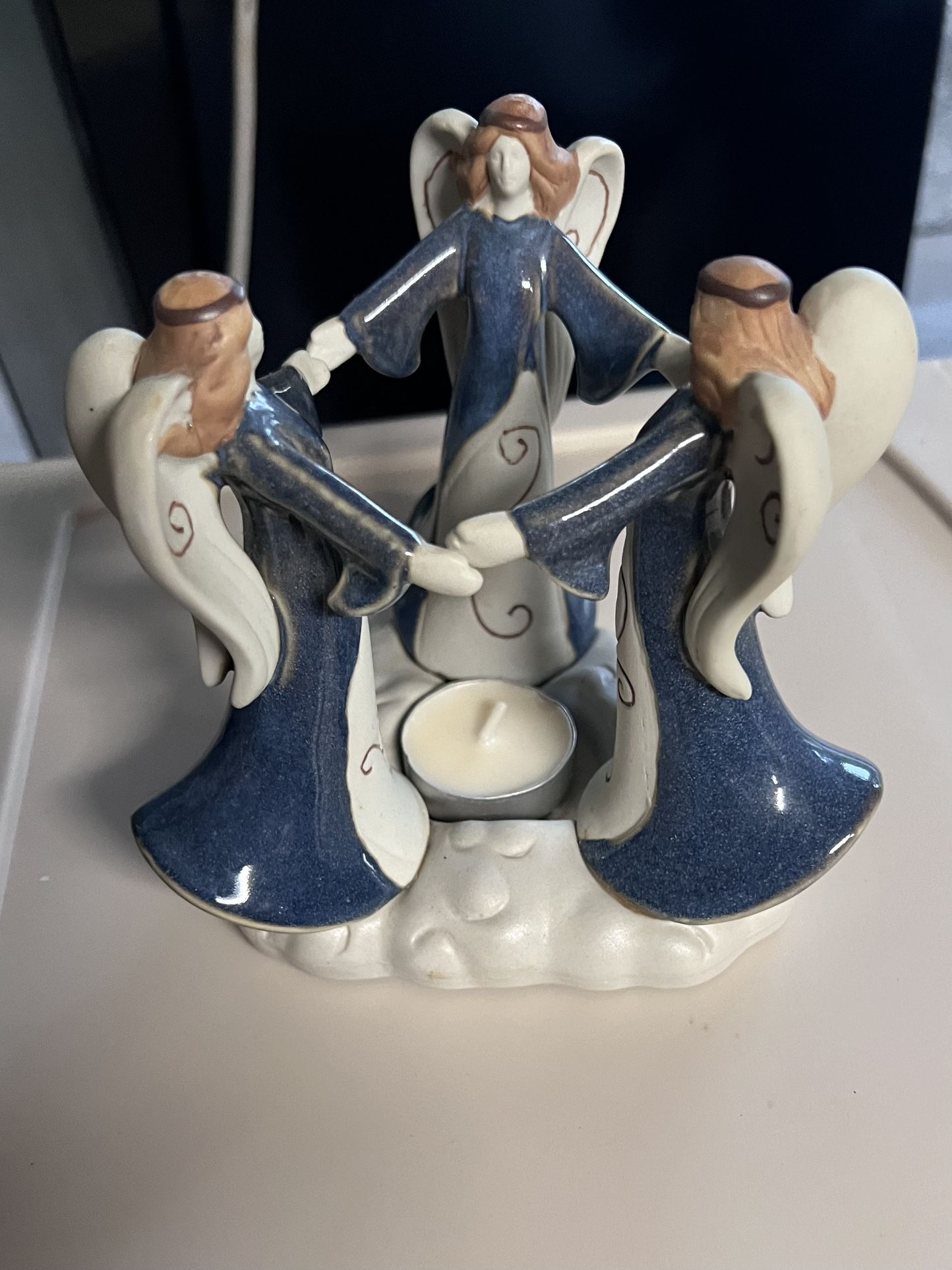 3 angels holdings hand w/tea-light candle