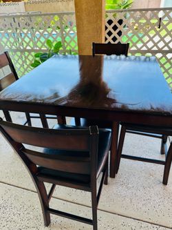 Dining table with four leather chairs.