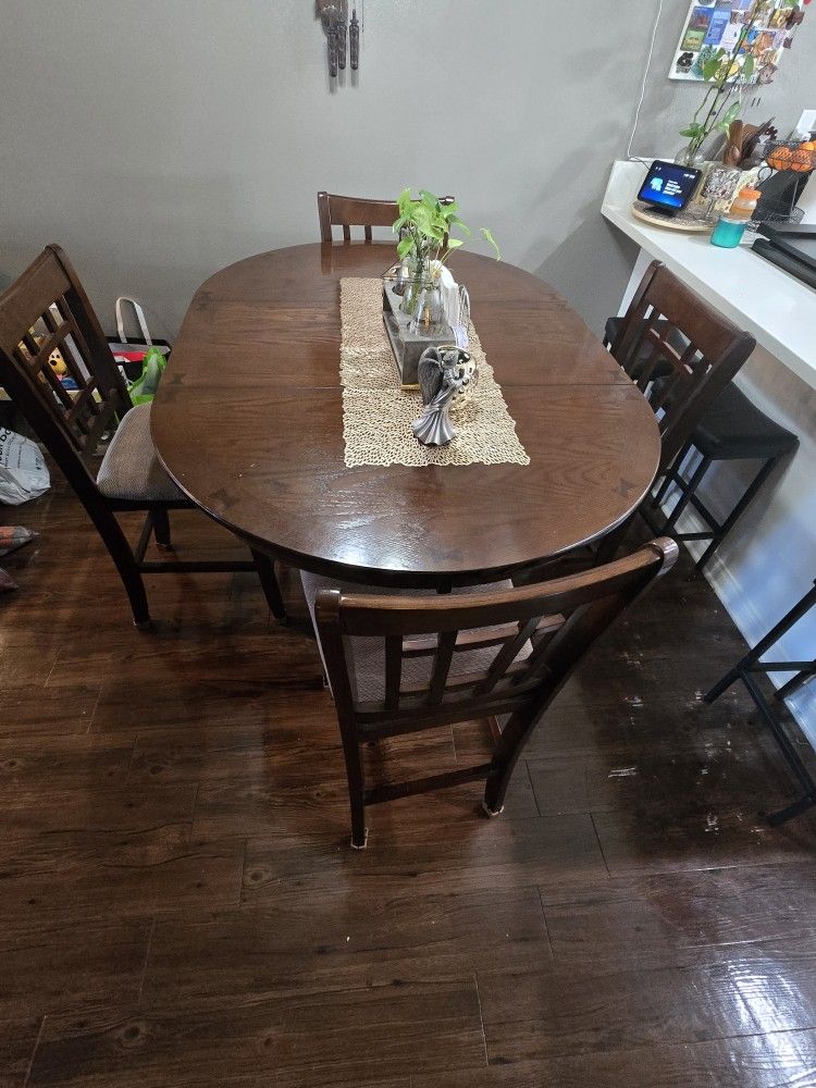 Brown wood oval dining table and chairs set