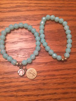 2 Beaded Stretch Bracelets. One has 2 charms