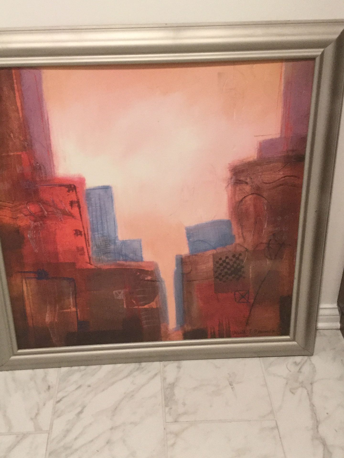 CONTEMPORARY FRAMED PAINTING. CITYSCAPE. ARTIST SIGNED- URSULA J. BRENNER. SILVER PAINTED FRAME. WEAR MARKS ON FRAME (see picture). 38” x 38”.