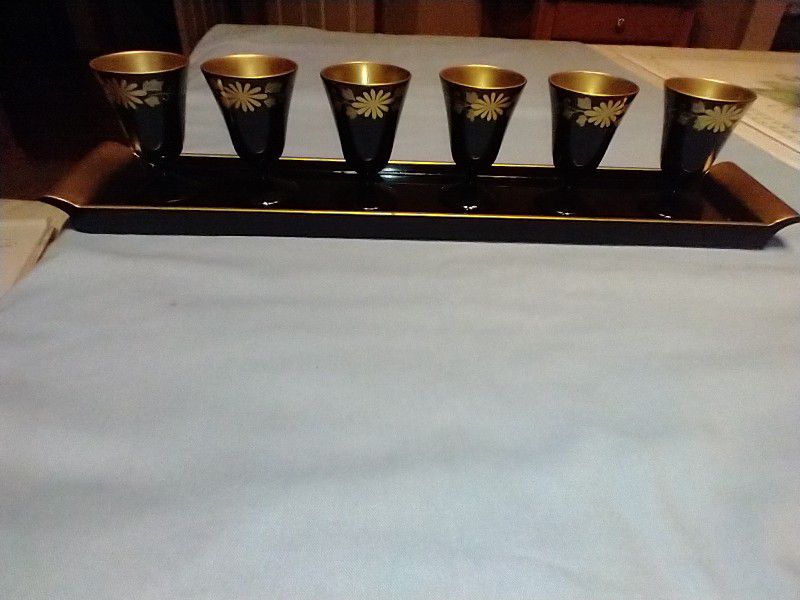

Japanese Sake, Black & Gold Lacquered stemmed, tray 15.25” long x 3" wide, 2 625" high x 1.75" goblet--