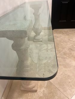 glass-top console table with carved decorative pedestal leg