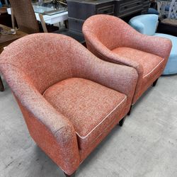 Pair Of HomePop Modern Barrel Accent Chairs in a textured orange/coral fabric