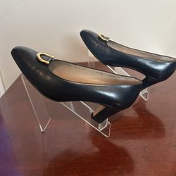 Black leather Salvatore Ferragamo pumps with gold buckle