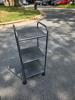 Three-tier metal utility cart with wheels.