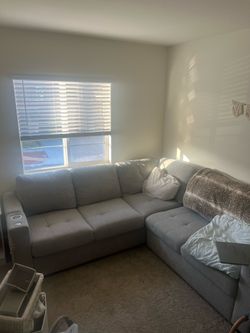 Grey sectional couch, with pull out and charger outlets