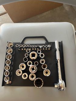 socket set organizer tray holding a chrome ratchet and a collection of assorted sockets.