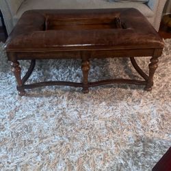 Brown leather ottoman with a wooden frame and an integrated tray. 