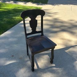 Dark brown wooden side chair with a vase shaped central splat and curved front legs