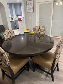 Beautiful high end walnut or mahogany table with four chairs with neutral colors of grey, about and mustard 4 chairs