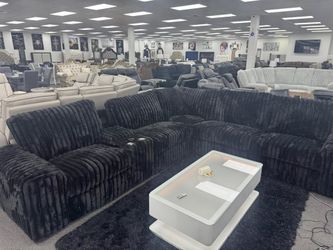 Plush corduroy black large power reclining sectional with surround sound.