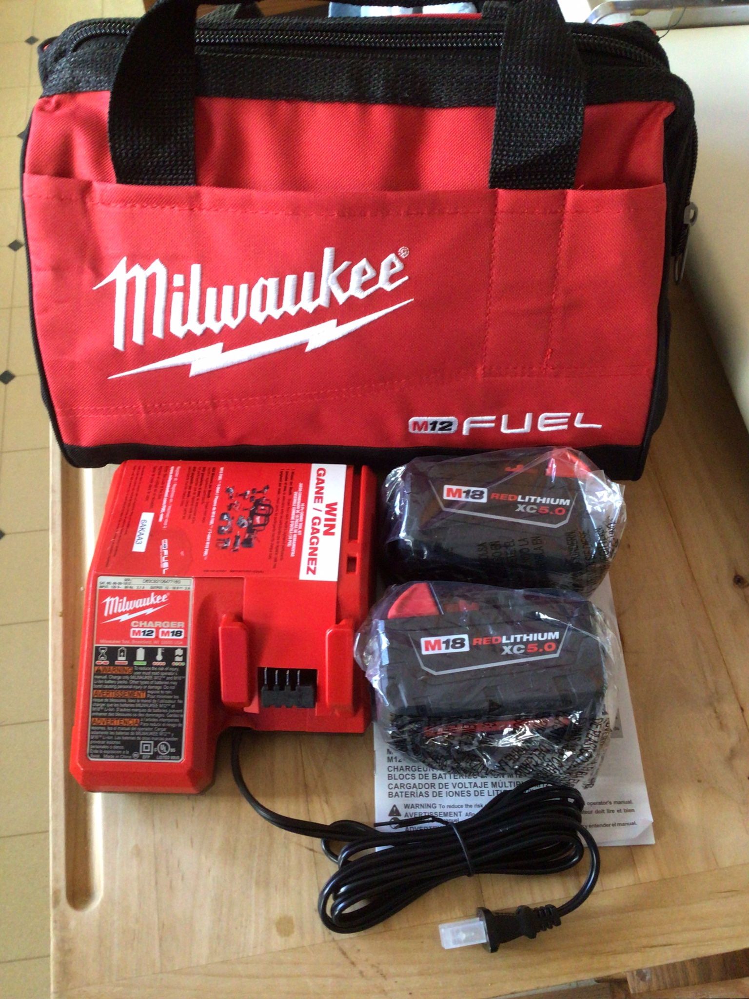 2 Milwaukee M18 XC5.0 Batteries With M18/M12 Charger And Tool Bag. Everything Is Brand NEW . NUEVO.