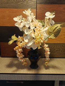Forever flowers in a beautiful black vase. Orchids and champagne wisteria
