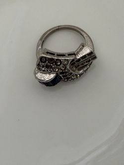 style ring,  a blue sapphire gemstone, surrounded by accent stones, set in Sterling silver