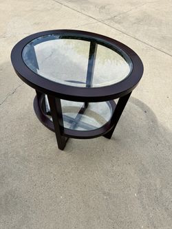Hammary Urbana oval end table featuring a dark wood finish and an inset glass top