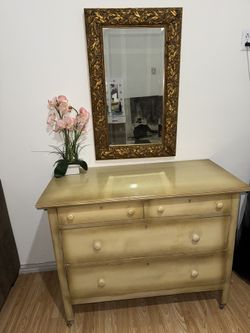 Wooden wardrobe with wheels, includes a mirror.