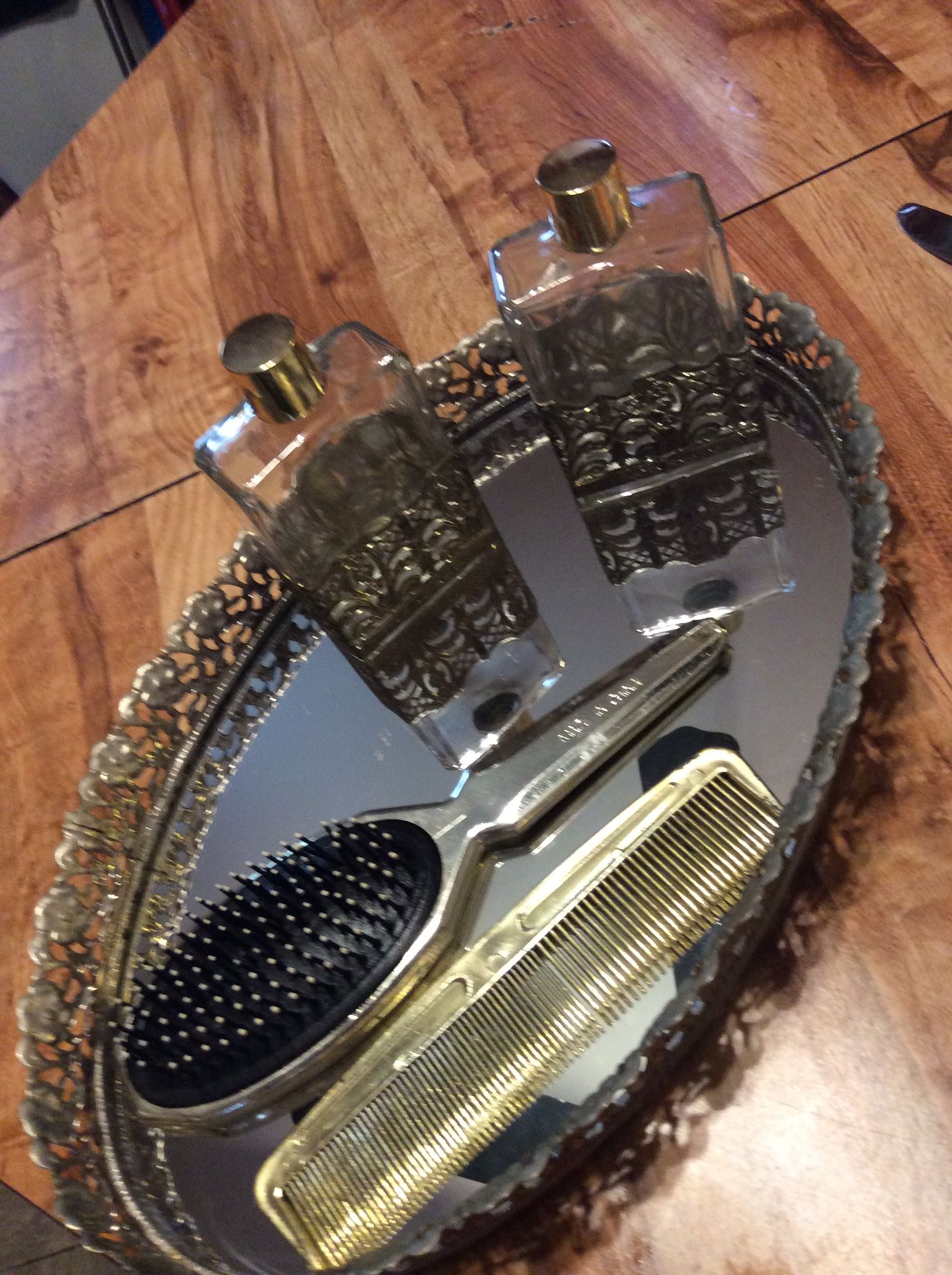 Beautiful comb brush and perfume bottles on mirror base