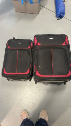 Two red and black matching Samsonite suitcases with wheels both expand