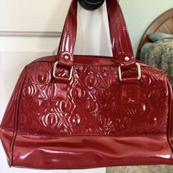 Used XOXO brand glossy patent leather handbag. Burgundy w/ 2 handles
