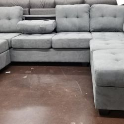 Light gray fabric reversible sectional with a matching storage ottoman 