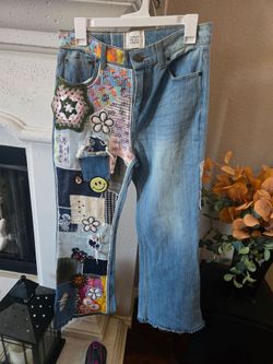 The BDG Urban Outfitters Hippie Embroidered Patchwork Flare Raw Hem High Waist Jeans are stylish and unique denim pants for women. Featuring a flared 