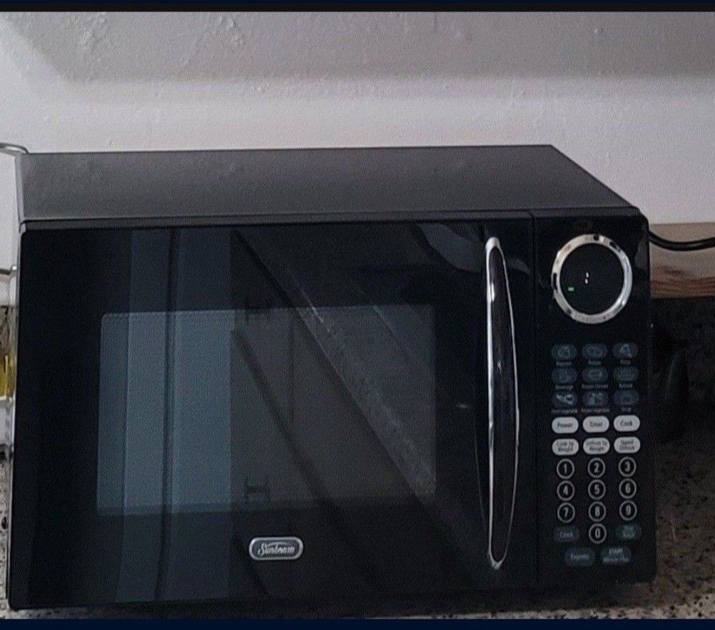 Sunbeam Microwave Oven With Turn Table. 900 Watts. Compact Size. 9 Preset Menus And Express Feature. Timer/Child Lock. In Great Condition.