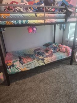 Bunk bed with on mattress with plastic still on