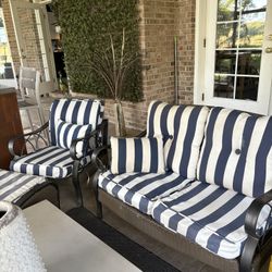 Outdoor loveseat with cushions and side chair with ottoman matching