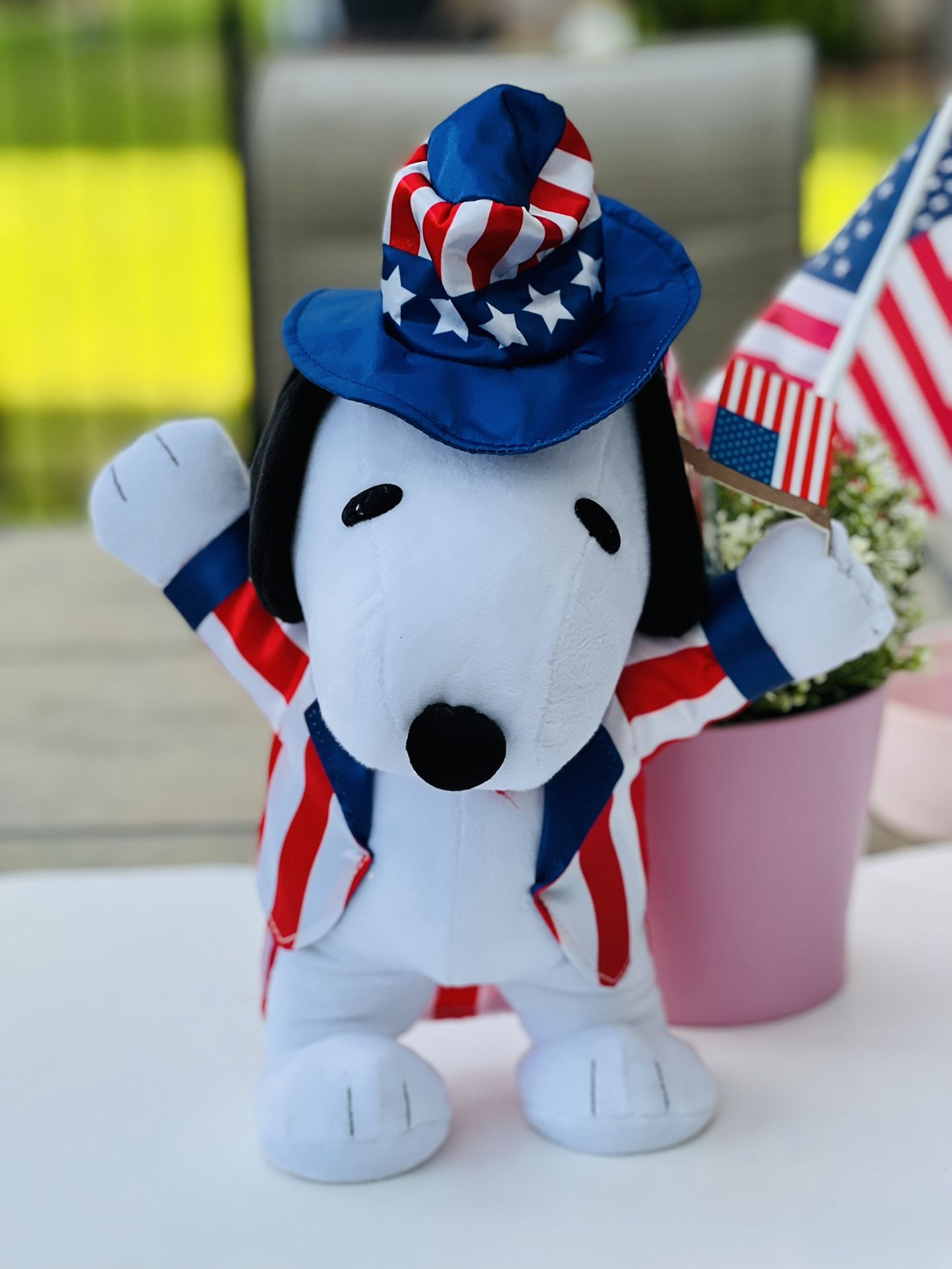 Peanuts Snoopy 4th of July dancing plush doll. He dances to Yankee Doodle in his patriotic coat and hat waving the US flag. 12” tall.