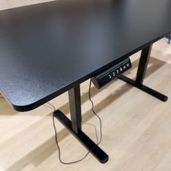 Large black desk with adjustable height. Size: 29.5” x 63”