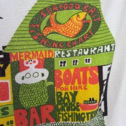 Vintage 70s Cannon Novelty Beach Terry Towel Charming Pier Fish Mermaid Vignettes with fringe on both ends 53” x 24”.