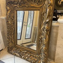 large Italian Gilt  ornate wall mirror with intricate carvings,  beveled edges and dental molding