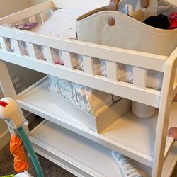 White baby changing table with changing pad and cover