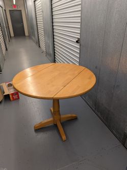 Drop-leaf round wooden table