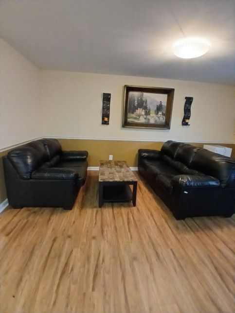 Small And Big Black Couch And A Table
