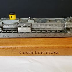 Model boat cruises costa luminosa which was metal silver on wooden stand