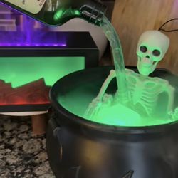 Cauldron With Skeleton And Floating Bottle