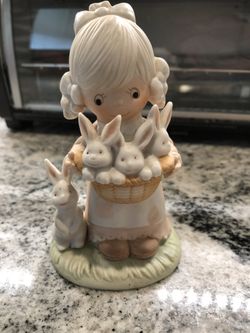Figure of little girl holding a basket of bunnies
