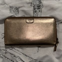 Fossil leather zip-around clutch wallet in a metallic gold color. 