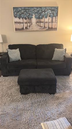 Dark gray couch, ottoman, and pillows