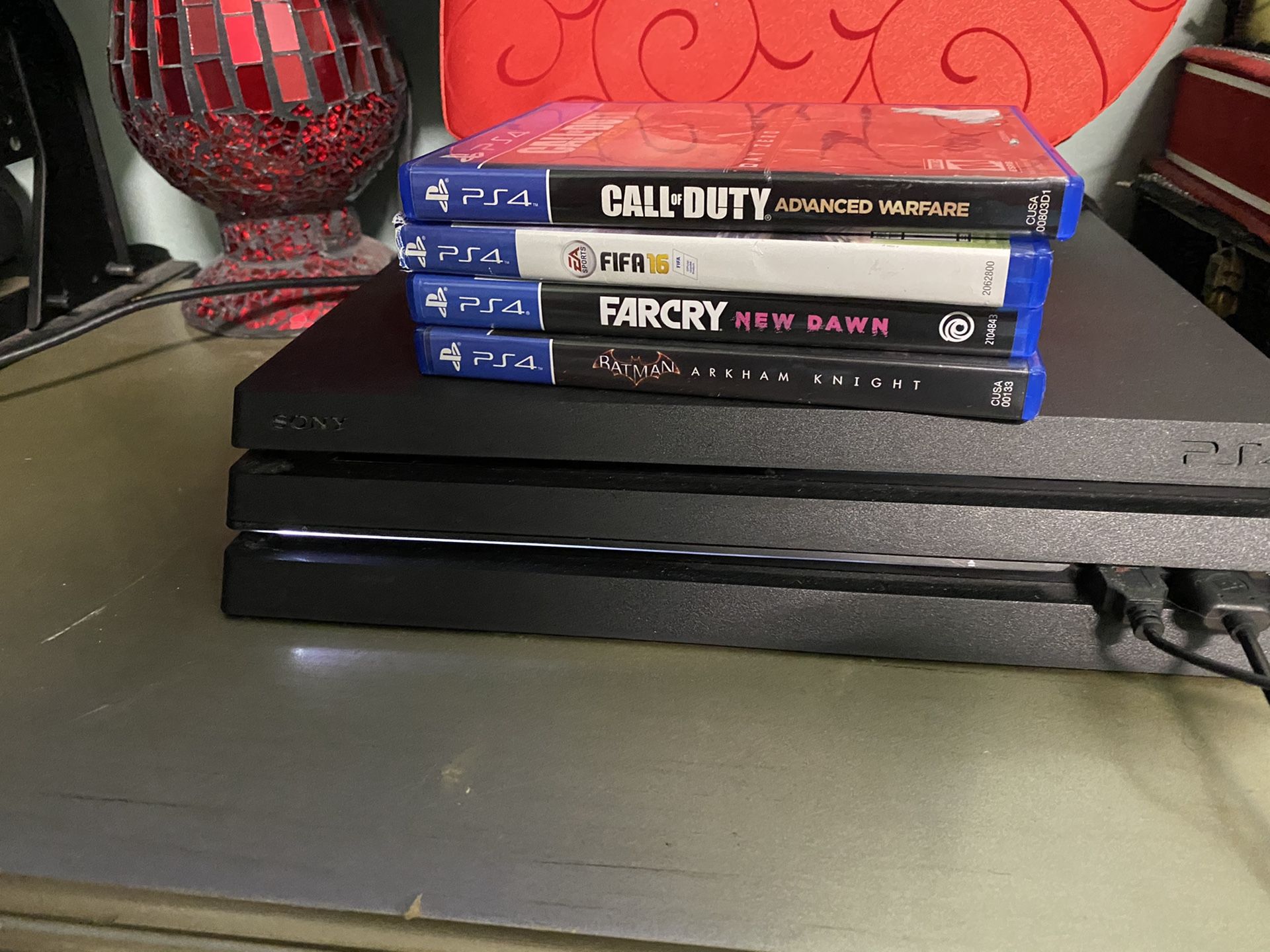 PlayStation 4 Pro with controller and cables and 4 games