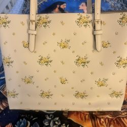 Coach Floral Print Tote Bag  Elegant Coach tote bag crafted in smooth leather with a delicate floral print design. Features long shoulder straps, top 