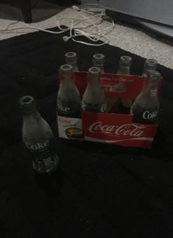 Antique coke bottles plus metal official coke six pack carrier