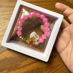 Brand new  pink beaded bracelet features rose quartz and a distinctive pendant, similar to styles often associated with UV awareness or symbolic natur