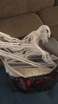 Large bundle of white plastic hangers