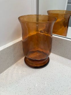 8 inch tall and 5 inch across amber glass candle holder/ vase
